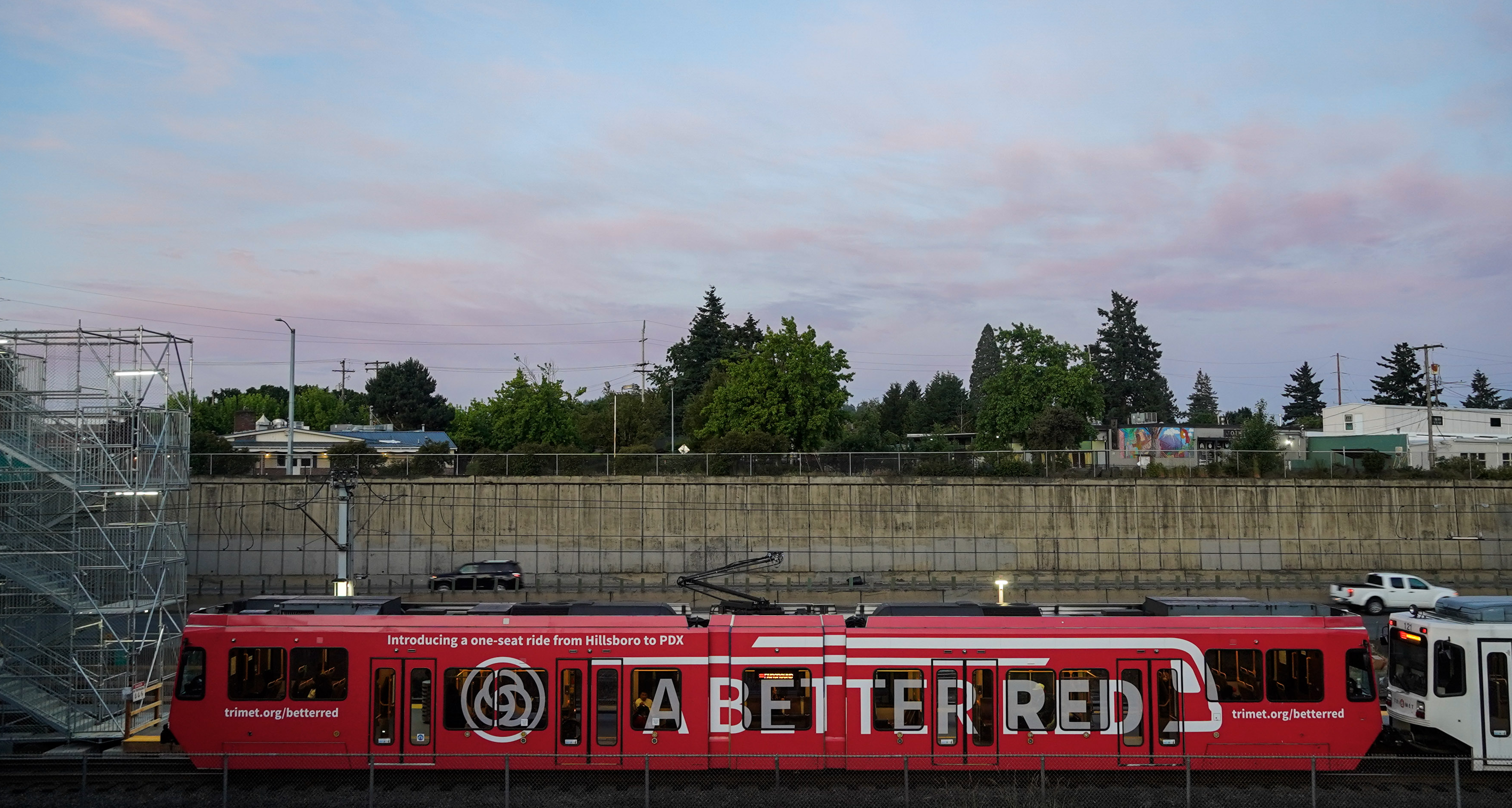 MAX train with 'A Better Red' vehicle wrap is waiting at NE 82nd station.