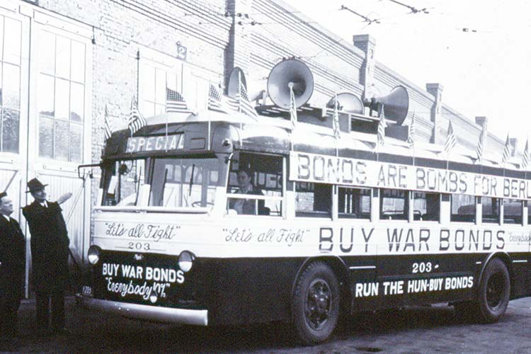 Transit bus featuring an advertisement during WWII reading 'Buy War Bonds'