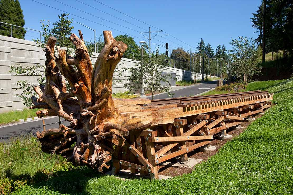 'One Tree Trestle' - a tree trunk on its side with repeating wooden blocks attached in a vertical pattern