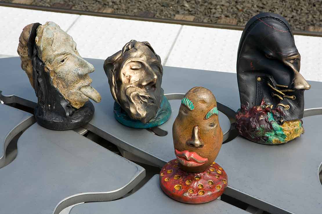 The Tigard Interactivator detail - abstract heads with masks one of which looks like a leather shoe
