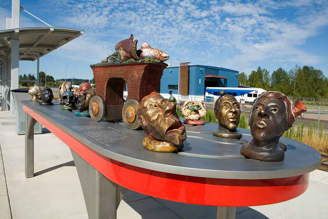 The Wilsonville Interactivator sculptural heads with masks on a metal table