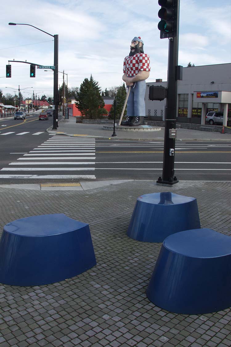 Seating sculpture - 3 horseshoe shaped stools in blue metal with Paul Bunyan in the background