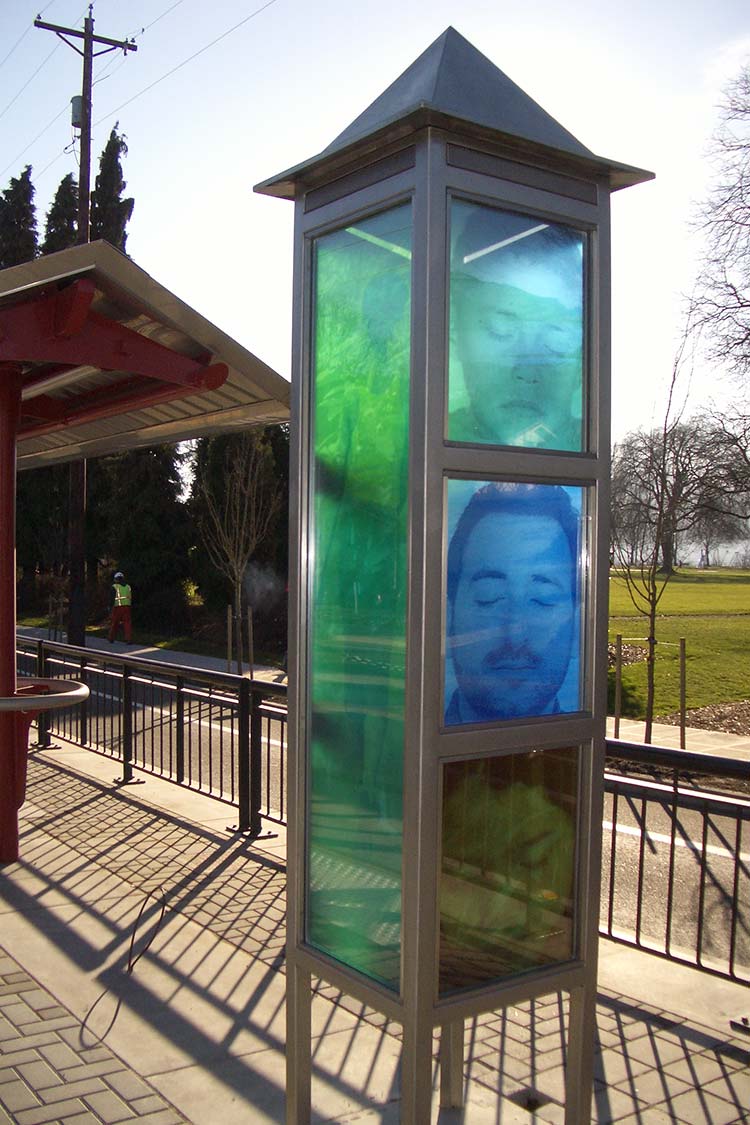 Light tower is a tall box with 3 glass frames on one side with faces in the frames